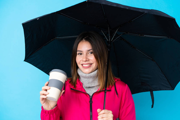 Молода жінка тримає парасольку і каву, щоб захопити ізо
 - Фото, зображення
