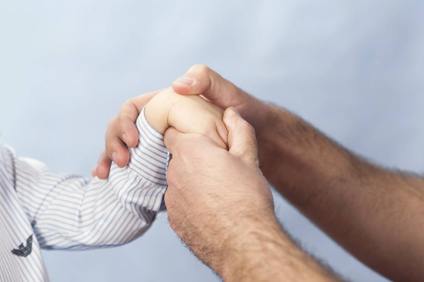 Ein Kinderarzt untersucht die Hände des Kindes, ein Dermatologe behandelt die Hände und betrachtet die Haut, massiert Hände und Finger. - Foto, Bild