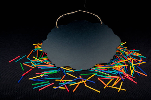 Чорна дошка оголошень у формі бульбашки мовлення на барвистих паличках
 - Фото, зображення
