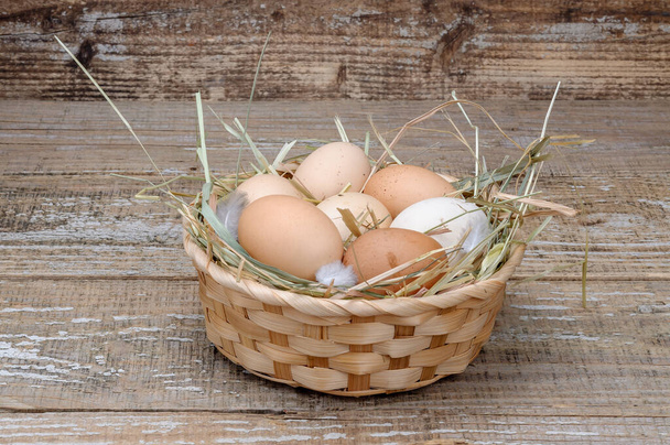 Корзина с домашними куриными яйцами на деревянном фоне
. - Фото, изображение