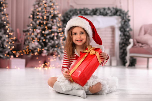 Cute little child with Christmas gift at home - Zdjęcie, obraz