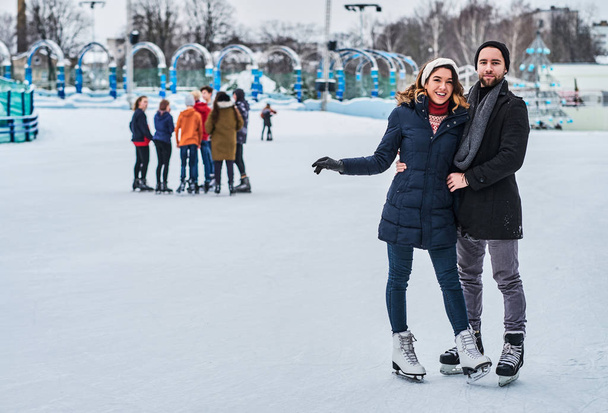 Szczęśliwa para randkowa na lodowisku, przytulanie i korzystających z czasu zimowego - Zdjęcie, obraz