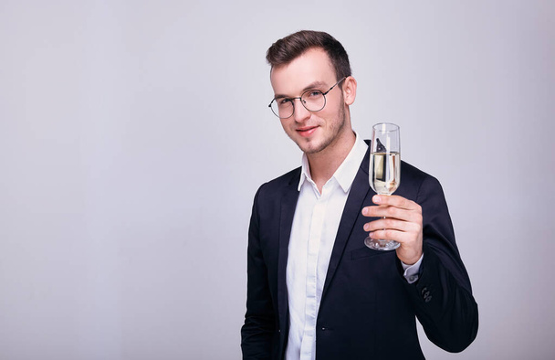 Charming blond in a suit with a glass in his hands. - Foto, afbeelding