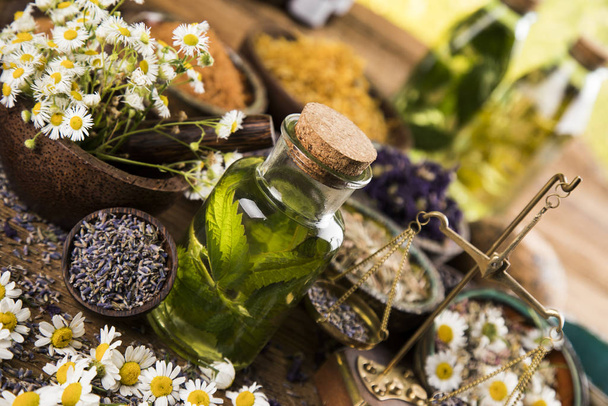 Świeże zioła i olejki, drewniane tło stołu - Zdjęcie, obraz