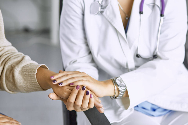 Mujer médico calma paciente y toma de la mano
 - Foto, imagen