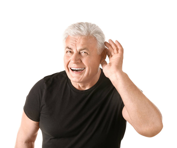 Hombre maduro con problemas de audición sobre fondo blanco - Foto, imagen