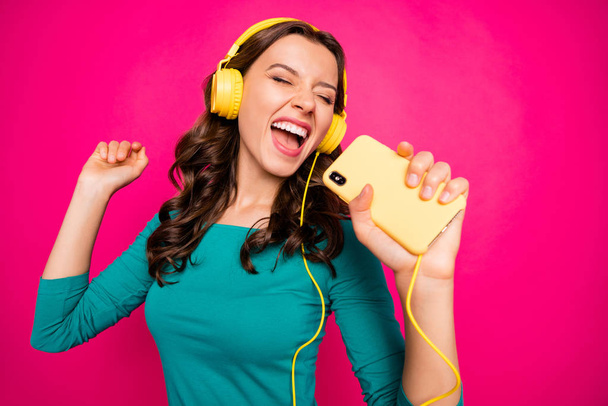 Photo of cheerful positive nice curly wavy youngster screaming into imaginary microphone telephone inspired by favorite rock band singing isolated vivid color background - Foto, imagen