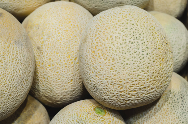melons stacked for retail sale - 写真・画像