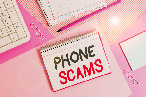 Writing note showing Phone Scams. Business photo showcasing use of telecommunications for illegally acquiring money Writing equipments and computer stuffs placed above colored plain table. - 写真・画像