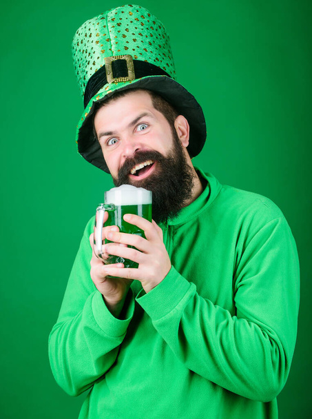 Fest and holiday menu. Dyed green traditional beer. Alcohol beverage. Lets start patricks party. Irish tradition. Man brutal bearded hipster drink beer. Irish pub. Drinking beer part celebration - Photo, Image