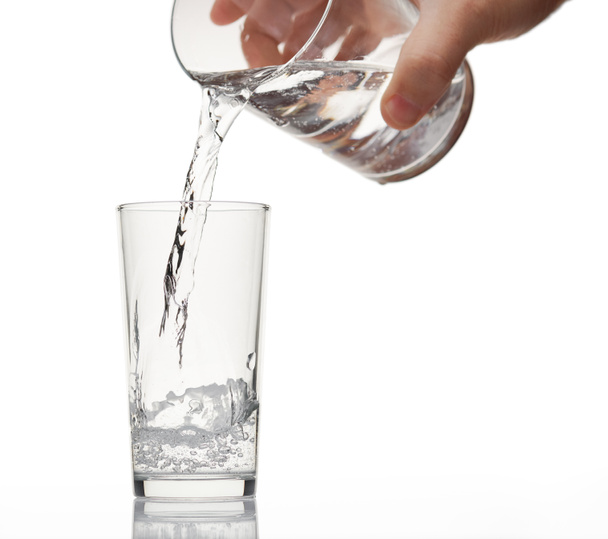 pouring sparkling water in a glass on white background, isolated object - Photo, Image
