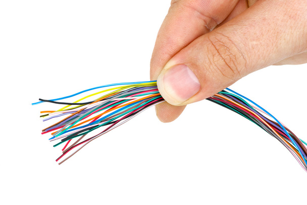 Mano sosteniendo racimo de cables de diferentes colores
 - Foto, imagen