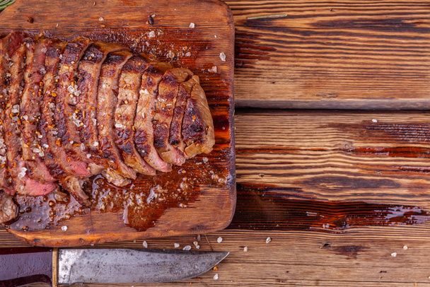 Sliced Grilled Meat Beef Steak Ribeye with Spices on Rustic Wooden Cutting Board - Fotoğraf, Görsel
