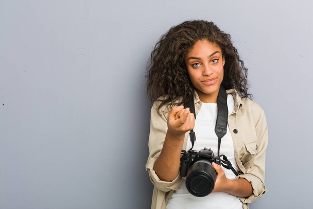 Genç Afrikalı Amerikalı fotoğrafçı kadın kamerayı sana çeviriyor sanki seni davet ediyormuş gibi.. - Fotoğraf, Görsel