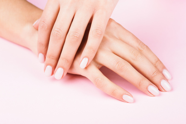 Females hands with classic pastel manicure. - Фото, изображение