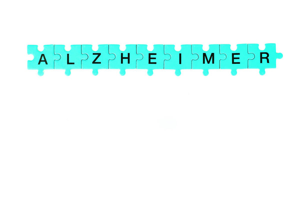 Αλτσχάιμερ, η λέξη Αλτσχάιμερ αποτελείται από παζλ κίτρινου, μπλε, λιλά χρώματος. - Φωτογραφία, εικόνα