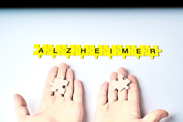 Alzheimerova choroba, koncept, slovo Alzheimer se skládá z hádanek ve žluté s černými písmeny - Fotografie, Obrázek