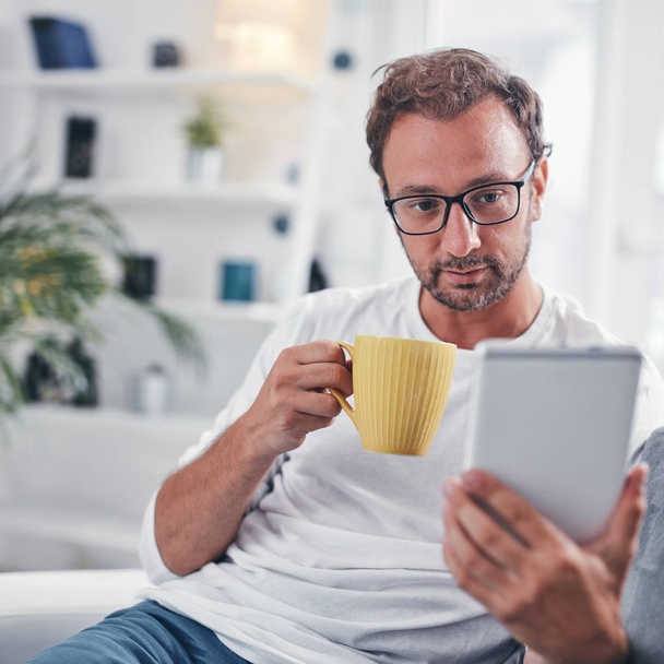 Man met tablet, surfen online en koffie drinken. - Foto, afbeelding