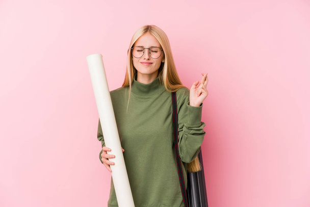 Νεαρή ξανθιά φοιτήτρια αρχιτεκτονικής σταυρώνει τα δάχτυλα για την τύχη - Φωτογραφία, εικόνα