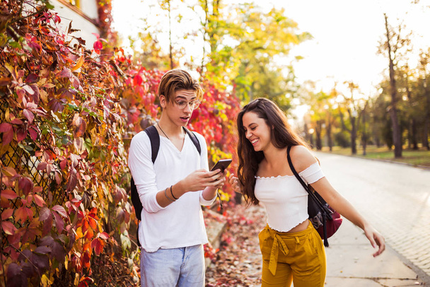 Feliz alegre joven pareja riendo sosteniendo el teléfono hablando de f
 - Foto, imagen