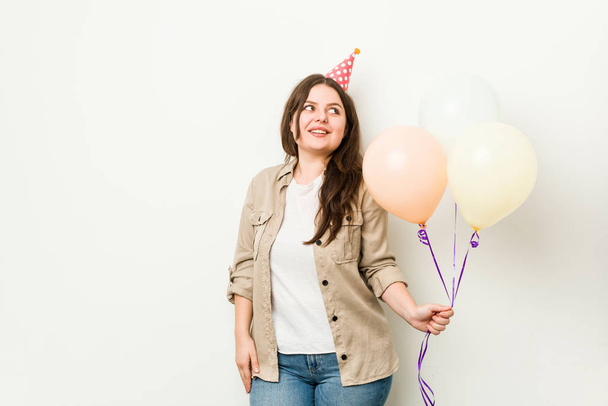 Young plus size curvy woman celebrating a birthday looks aside smiling, cheerful and pleasant. - Photo, Image