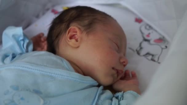 Der neugeborene Junge liegt im Kinderwagen, schläft mit geschlossenen Augen. Baby neugeboren ersten Augenblicke des Lebens - Filmmaterial, Video