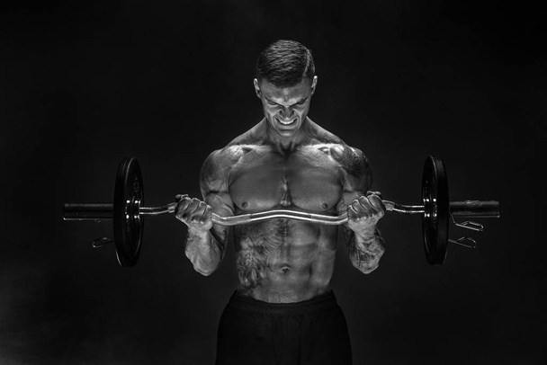 Hardy man doing exercise with heavy bar - Foto, Imagen