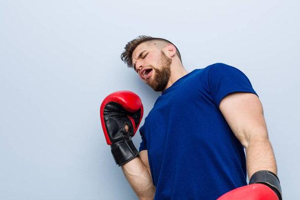 Young caucasian man wearing a boxing gloves - Foto, Bild