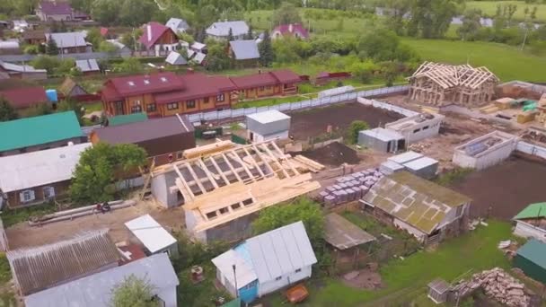 木造フレームの建設中の家のトップダウンの空中ビュー。クリップ。村に囲まれた建築過程における生態系の家. - 映像、動画