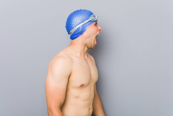 Jonge professionele zwemmer schreeuwend naar een kopieerruimte - Foto, afbeelding