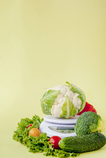 Fresh vegetables on vase on yellow background. Healthy eating, d - Foto, afbeelding