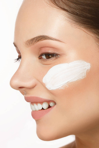 Young woman with moisturizing facial mask on white background.  - Valokuva, kuva