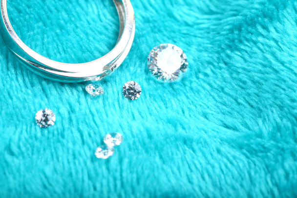 Nahaufnahme eines Verlobungsrings aus Weißgold mit Diamanten auf isoliertem grünem Hintergrund - Foto, Bild