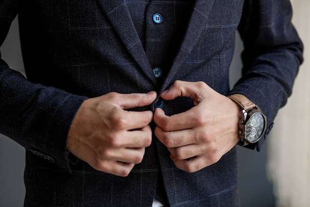 Man gets ready for work by buttoning up his business shirt. Groom's morning preparation before wedding - Foto, immagini