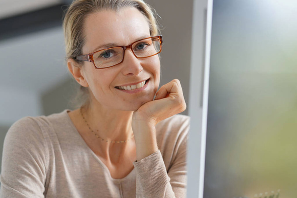 young woman with glasses in an office - Fotoğraf, Görsel