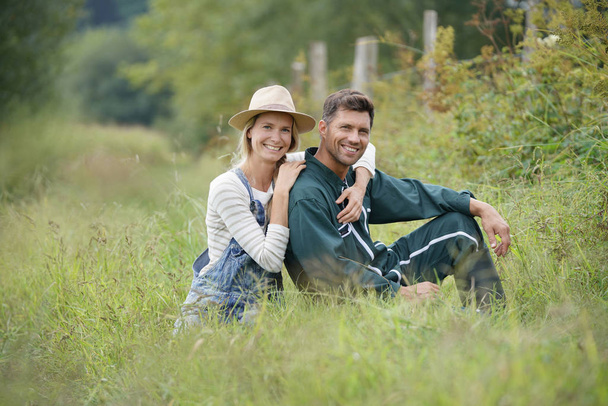 Couple of farmers sitting in field - Photo, Image
