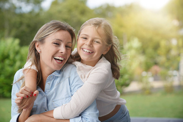 Portrait of cheerful mother and daughter - Foto, imagen