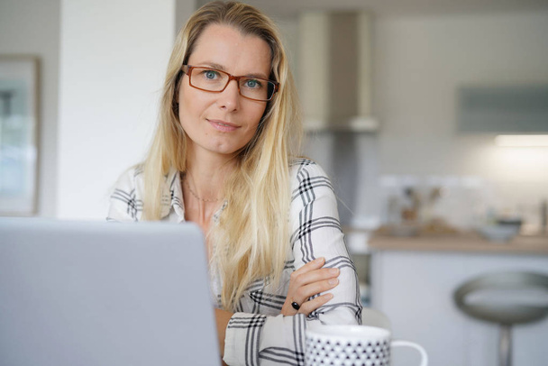 young woman with glasses working in front of her computer - Foto, Bild