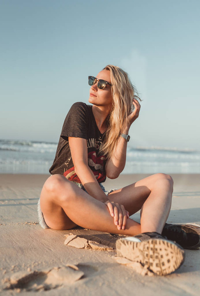 Портрет охлаждающей блондинки на песчаном пляже в Португалии Атлантический океан
 - Фото, изображение