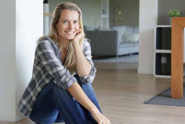 Beautiful blond woman relaxing at home, sitting on floor - Fotoğraf, Görsel