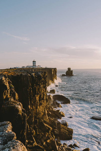 Leuchtturm am Rande einer Klippe große Meereswellen krachen auf einen Felsen peniche portugal - Foto, Bild