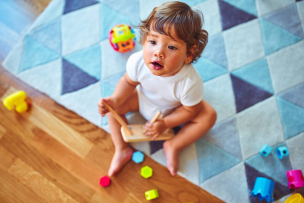 Hermosa niña jugando con juguetes en la alfombra
 - Foto, imagen