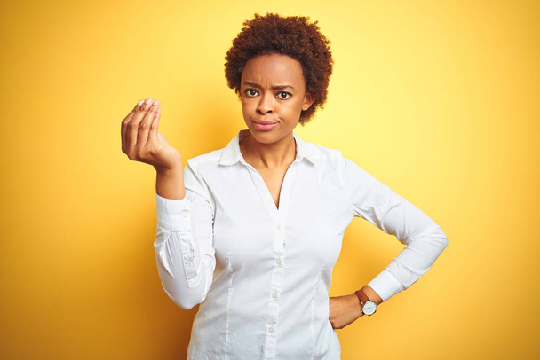 donna d'affari afroamericana su sfondo giallo isolato facendo gesto italiano con mano e dita espressione fiduciosa
 - Foto, immagini