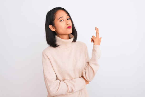 Young chinese woman wearing turtleneck sweater standing over isolated white background Shooting and killing oneself pointing hand and fingers to head like gun, suicide gesture. - Photo, Image