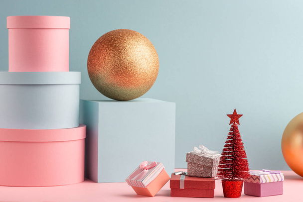 Teal and pink gift boxes, red Christmas tree and golden balls - Fotografie, Obrázek