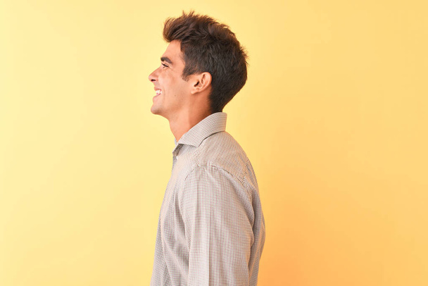 Nuori komea mies päällään rento paita seisoo yli eristetty keltainen tausta etsii sivuun, rentoutua profiili aiheuttaa luonnolliset kasvot luottavainen hymy
. - Valokuva, kuva