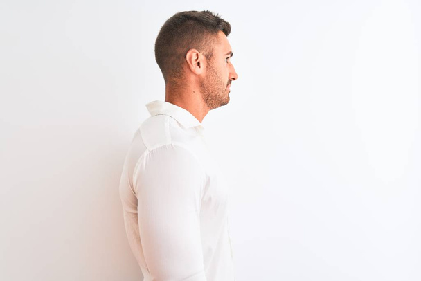 Young handsome business man wearing elegant shirt over isolated background looking to side, relax profile pose with natural face with confident smile. - Foto, imagen