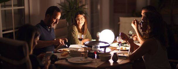 Kaunis perhe päivällisellä puhuu ja hymyilee terassilla
 - Valokuva, kuva