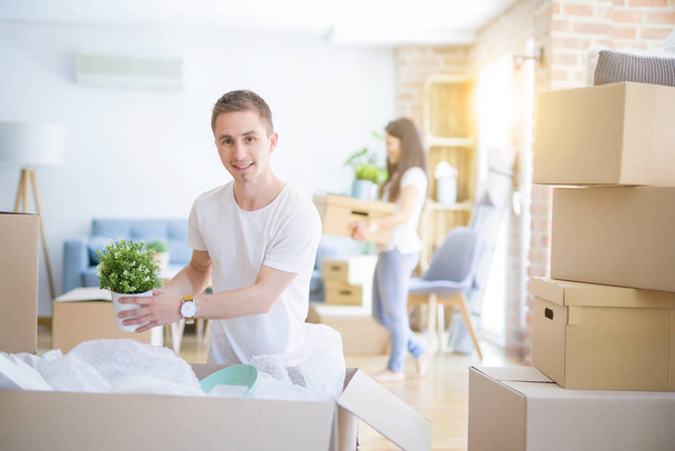 Young beautiful couple  at new home around cardboard boxes - Photo, Image