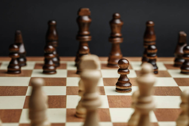 Σκακιστικά κομμάτια σε σκακιέρα σε σκούρο φόντο - Φωτογραφία, εικόνα